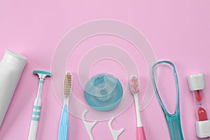 Flat lay composition with tongue cleaners and teeth care products on pink background, space for text