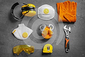 Flat lay composition with tools and safety equipment on grey