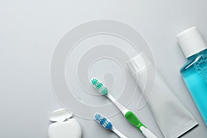 Flat lay composition with toothpaste, oral hygiene products and space for text on white