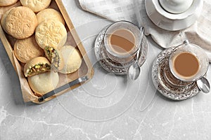 Flat lay composition with tray of cookies for Islamic holidays and cups. Eid Mubarak