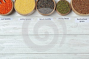 Flat lay composition with types of legumes and cereals on white wooden table, space for text. Organic grains
