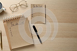 Flat lay composition with unfilled To Do lists and glasses on wooden table. Space for text