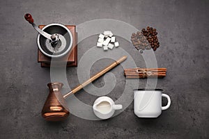 Flat lay composition with vintage manual grinder and turkish coffee pot on black table