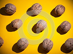 Flat lay composition with walnuts on yellow background.