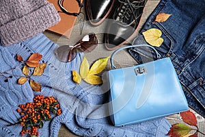 Flat lay composition with warm clothes and autumn leaves on background