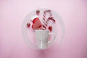 Flat lay composition with white cup and christmas candies on a pink background. Christmas composition