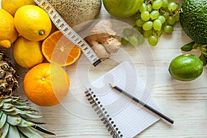 Flat lay composition withmeasuring tape, healthy vegetables and fruit on wooden background. Weight loss diet