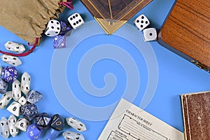 Flat lay concept design for tabletop role playing with blue and white RPG dices, character sheet and rule books