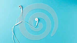 Flat lay concept: headphones on pastel backgrounds. white headphones on a blue background, top view, copyspace