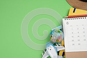 Flat lay concept of travel accessories vacation trip and long summer weekend planning on green table with blank space for text