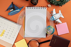 Flat lay concept of travel accessories vacation trip and long summer weekend planning on orange color table with blank space for