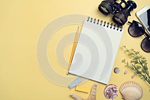 Flat lay concept of travel accessories vacation trip and long summer weekend planning on yellow table with blank space for text