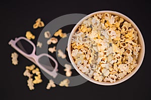 Flat lay. Copyspace. Cinema Concept. Background. Popcorn, cup and 3d glasses on a black background