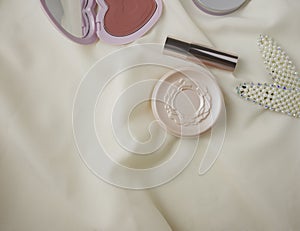 Flat lay cosmetics on silk fabric background