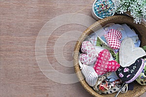 Flat lay Crafts made with fabric is a heart shape with sewing tools and accessories on a wooden background