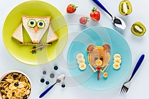 Flat lay with creatively styled children`s breakfast with berries and kiwi