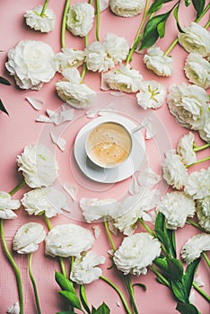 Flat-lay of cup of coffee surrounded with white ranunculus flowers