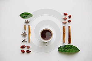 Flat lay a cup of fragrant and tasty herbal or black tea on a white surface and various ingredients