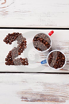 Flat lay cups with coffee beans and number two.