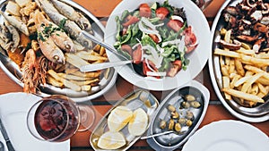 Flat lay of Cyprus fish and seafood meze with olives, lemon and Greek salad