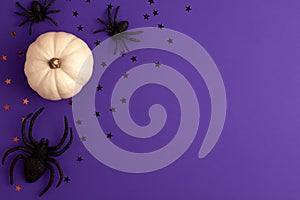 Flat lay of decoration white small Halloween pumpkin template star shapes and black horror spiders on vibrant purple background on