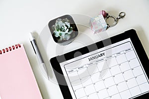 Flat lay desk with notebook, succulent flower, pen and calendar. Planning concept. Mockup, top view, overhead, desktop
