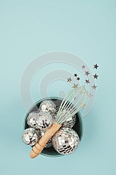 Flat lay with disco balls in the bowl with whisk.