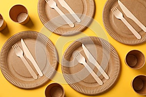 Flat lay with eco - friendly tableware on yellow background