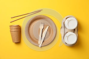 Flat lay with eco - friendly tableware on yellow background