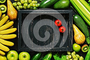 Flat lay empty wooden black tray and frame of fresh vegetables and fruits. Top view, copy space