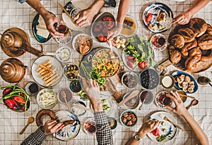 Flat-lay of family having Turkish breakfast over chekered linen tablecloth