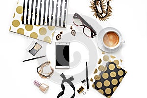 Flat lay fashion feminine home office workspace with phone, cup of coffee, stylish black gold notebooks, cosmetics and jewelry on