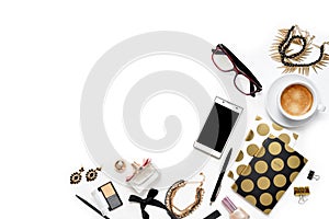 Flat lay fashion feminine home office workspace with phone, cup of coffee, stylish black gold notebooks, cosmetics and jewelry on