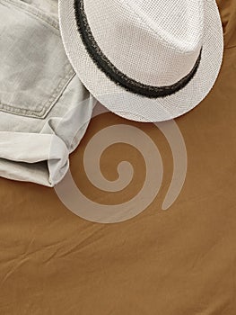 Flat lay fashion women summer beachwear accessories: shorts and hat on a beige vacation background. Top view. Copy space