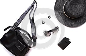 Flat lay female clothes and accessories collage, black womenâ€™s hat, glasses, earring, and cardholder isolated on white