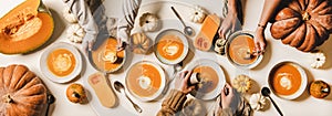 Flat-lay of female hands having dinner with fall pumpkin soup