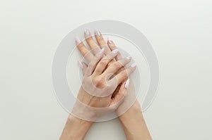 Flat lay feminine hands with manicure and nail painting draw. Flyer concept for a beauty salon with copy space on white