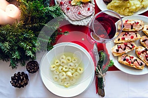 Flat-lay of festive table setting for holiday dinner with dishes. Traditional Italian Christmas dinner - tortellini with broth,