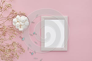 Flat lay flowers, photo frame on pink background
