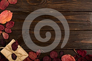 Flat lay frame of autumn crimson leaves and gift boxes on a dark