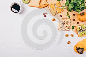 Flat lay frame healthy vegetarian breakfast composition, copy space. Cup of espresso coffee on white wooden table next to toast,