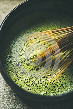 Flat-lay of freshly brewed Japanese matcha green tea, vertical composition