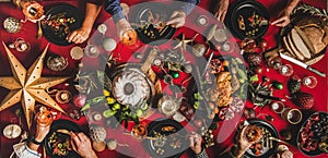 Flat-lay of friends celebrating Christmas over festive table, top view