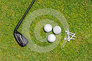 Flat lay with golf club, balls nad tees on green grass of golf course