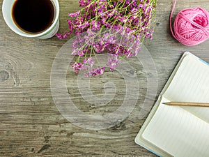 Flat lay grey wooden desk with stationery,flowers and coffee