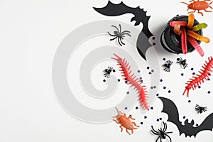 Flat lay halloween decorations on white table. Halloween banner mockup with spiders, bags, bats, confetti, treat. Top view with