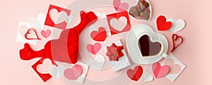 Flat lay of heart shaped cup of black coffee, gift box and candy on pink background with copy space. Valentine`s day, beverage