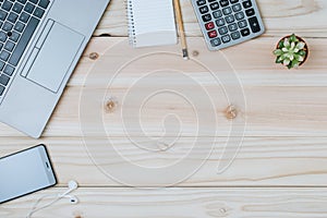 Flat lay of home office desk consist of laptop computer notebook, smarthphone, earphone, pencel, calculator and decorated with