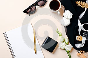 Flat lay home office desk. Female workspace with blank paper notebook, coffee cup, ring box, marshmallows and roses flowers on