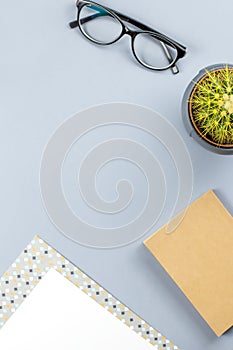 Flat lay home office desk. Female workspace with note book, eyeglasses, tea mug, diary, plant. Copy space